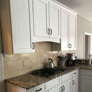 Kitchen with travertine backsplash after refinishing