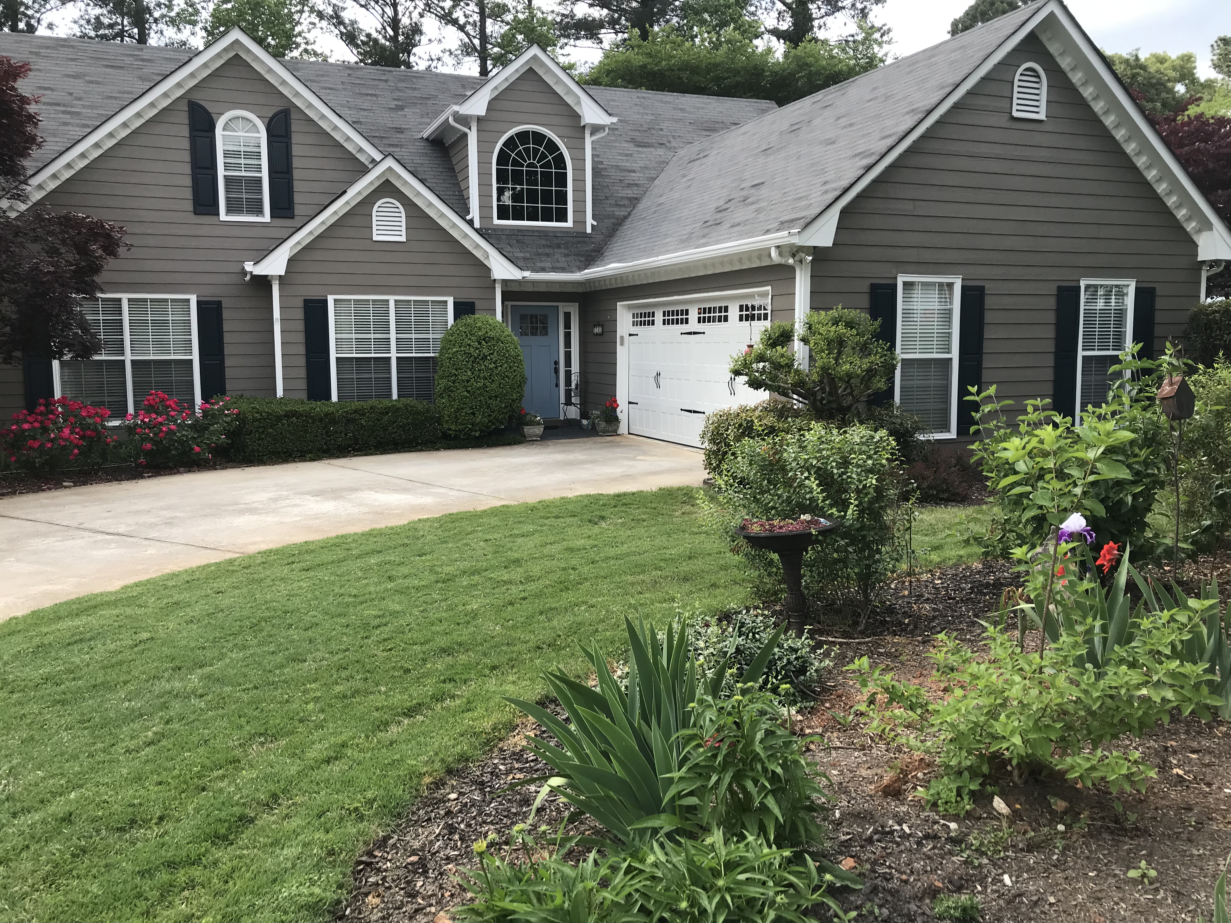 Two-story home exterior with painted shutters and front lawn